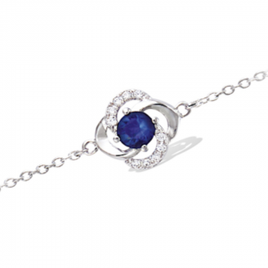 Bracelet en argent rhodié 925 millièmes d'une fleur montée d'une pierre bleu saphir et de strass