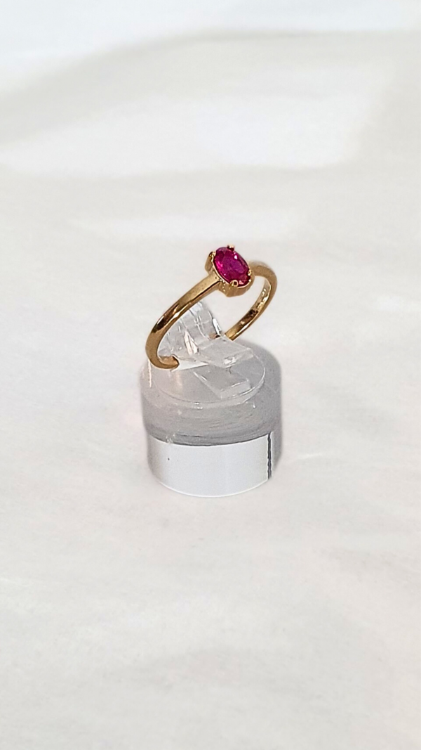 Bague solitaire sertie d'une pierre rouge rubis en présentation.