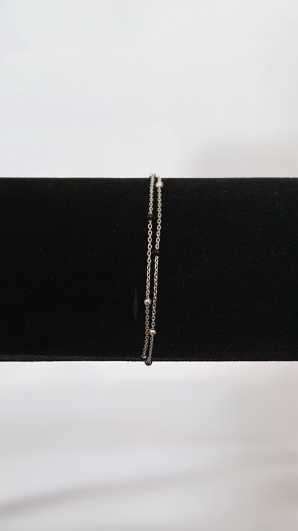 Bracelet double chaîne en argent rhodié 925 millièmes avec des perles noires sur présentoir
