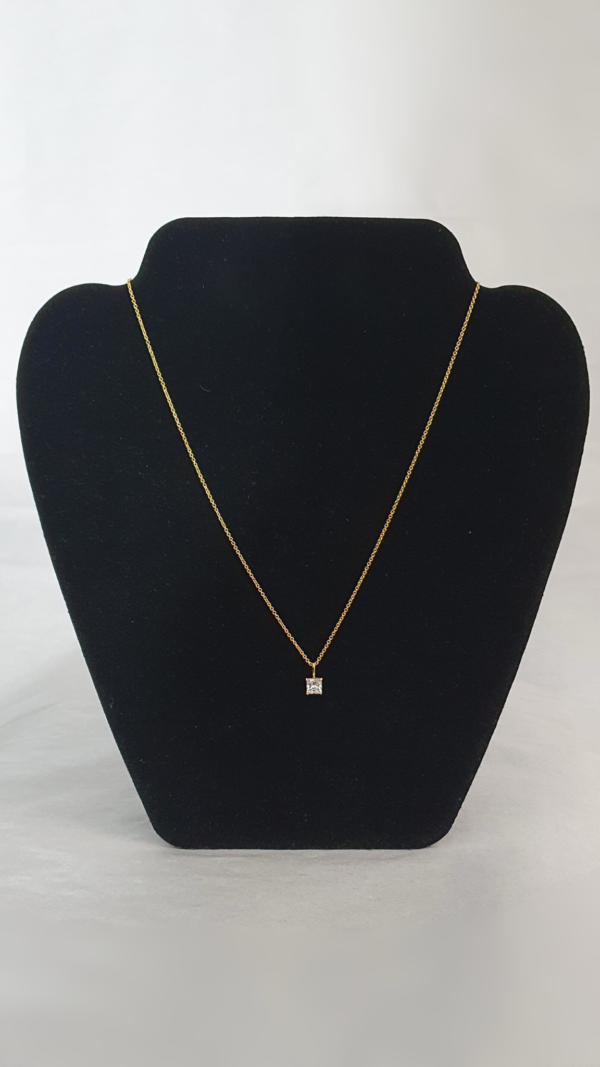 Collier plaqué or avec une pierre carrée blanche en pendentif sur présentoir