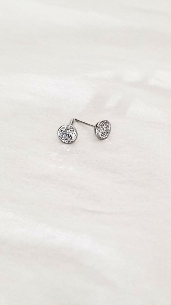 Boucles d'oreilles rondes en or gris et pierres en oxydes de zirconium en presentation