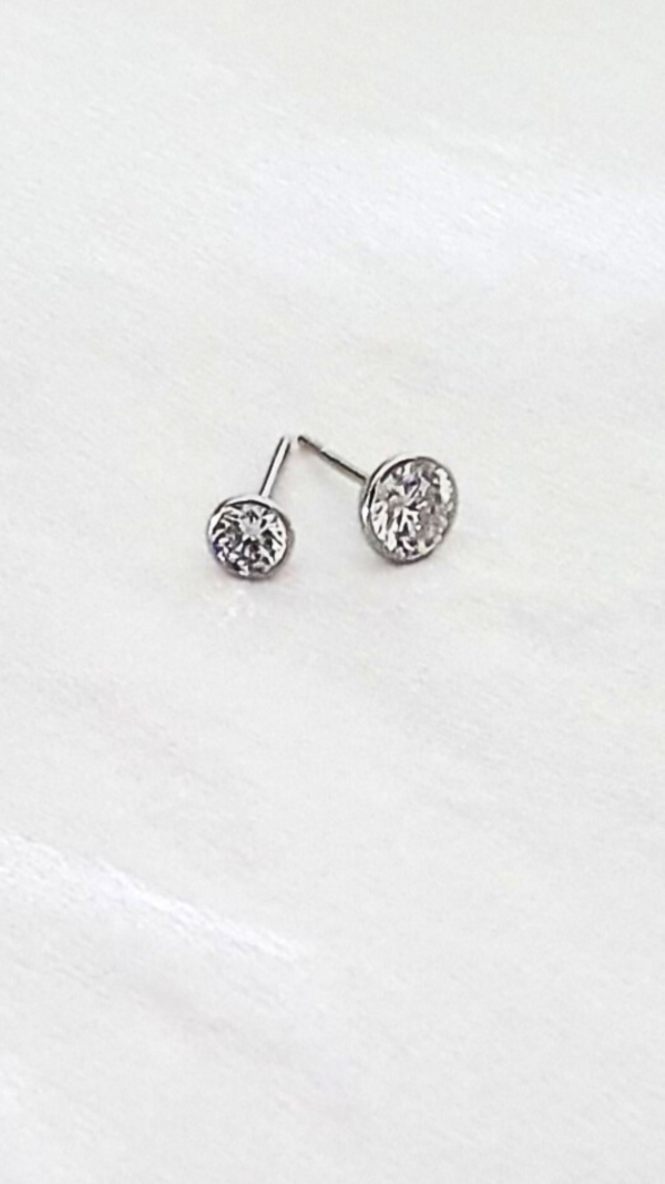 Boucles d'oreilles rondes en or gris et pierres en oxydes de zirconium en présentation