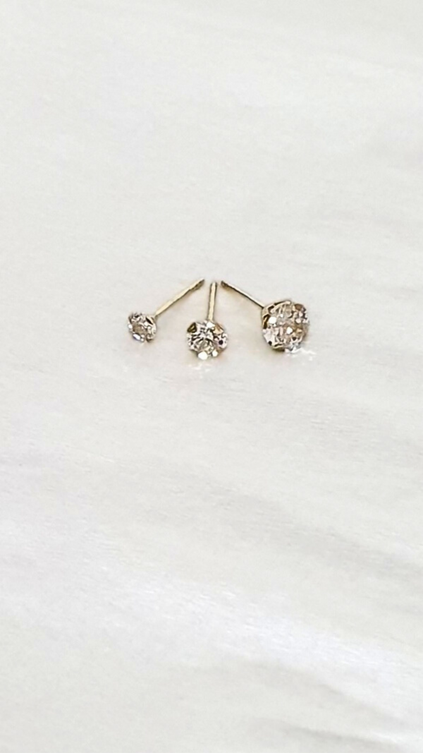 Assortiment boucles d'oreilles en or jaune 4 griffes et pierre oxyde de zirconium en présentation.